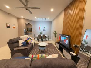 a living room with a couch and a tv at FunkyVila6 14Pax 4BR Near188Tower, HTTA, Airport in Kuantan
