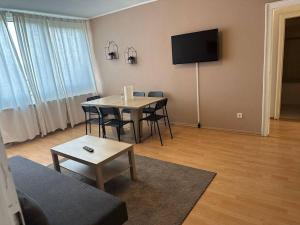 sala de estar con mesa y TV de pantalla plana en Ferienwohnung Neuss, en Neuss