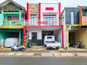 a white truck parked in front of a building at Labella Homestay 1 Syariah Dieng RedPartner in Dieng