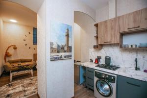 a kitchen with a sink and a washing machine at Lovely flat near the Boulevard Center of Baku in Baku