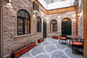a courtyard with a table and chairs and a brick wall at Lovely flat near the Boulevard Center of Baku in Baku
