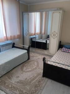 una camera con due letti e un grande specchio di Квартира в аренду береке a Tridtsatʼ Let Kazakhstana