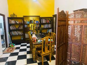 a room with a table and chairs and book shelves at Apartament 60 m2 in Dili