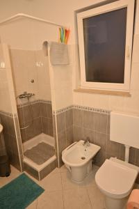 een badkamer met douche, toilet en wastafel bij Apartman Daiya in Rovinj +7 foto's