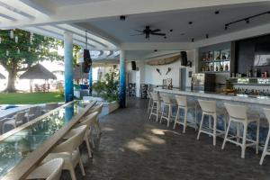 un bar dans un complexe hôtelier avec des chaises et un comptoir dans l'établissement Vida Homes Condo Resort, à Dauin