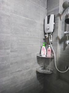 baño con ducha y dispensador de jabón en The Cozy Grey Riverine Diamond, en Kuching