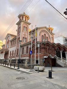 a large building with a clock tower on a street at Cozy 2 Bedroom Condo by Waterfront & Metro in Thessaloniki +22 photos
