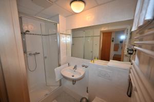 a white bathroom with a shower and a sink at Expotel Hannover Messe in Hannover