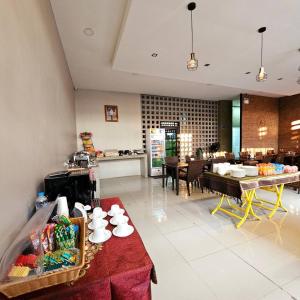 a kitchen with a table with cups and plates on it at Sawasdee​ Buriram​ Resort in Buriram