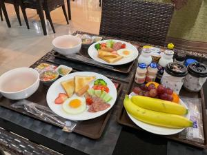 two trays of breakfast food on a table at Sawasdee​ Buriram​ Resort in Buriram +127 photos