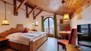 a bedroom with a bed and a table and a desk at Ferienhaus Goldenes Landl in Mittenwald
