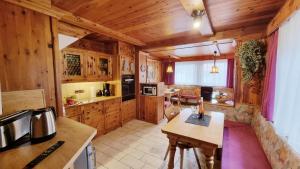 a kitchen with wooden cabinets and a table in a room at Ferienhaus Goldenes Landl in Mittenwald +7 photos