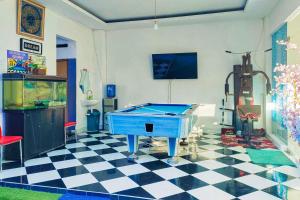 a room with a pool table on a checkered floor at RedDoorz Near RS UMMI Bogor in Slada