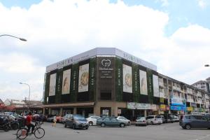 un edificio en una ciudad con coches y gente en bicicleta en Sojourn Guest House en Kuala Lumpur