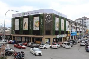 un estacionamiento con autos estacionados frente a un edificio en Sojourn Guest House en Kuala Lumpur