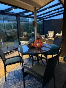 Un patio con una mesa y sillas en un patio. en Strandnahes Ferienhaus mit Wintergarten, grosser uneinsehbarer Garten, komplett eingezäunt, en Sint Maartensvlotbrug