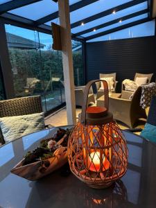 una linterna sobre una mesa con un plato de comida en Strandnahes Ferienhaus mit Wintergarten, grosser uneinsehbarer Garten, komplett eingezäunt, en Sint Maartensvlotbrug
