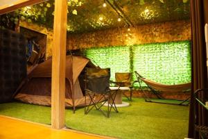 Una habitación con una tienda de campaña y una hamaca dentro. en Onjuku, en Iwada