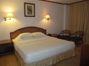 ein Schlafzimmer mit einem großen Bett in einem Hotelzimmer in der Unterkunft Sanbay Hotel in Sandakan