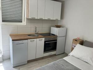 a small kitchen with a sink and a refrigerator at Sweet studio in Poljana