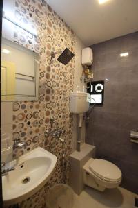 a bathroom with a toilet and a sink and a mirror at Golden Residency in Mumbai