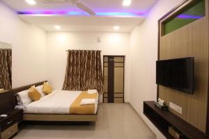 a bedroom with a bed and a flat screen tv at Golden Residency in Mumbai