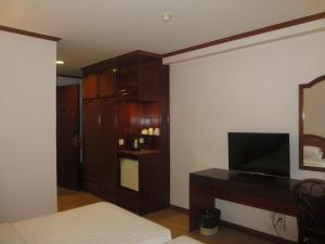 Sanbay Hotel في سانداكان: غرفة معيشة مع تلفزيون وخزانة