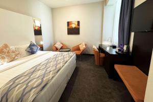 Een bed of bedden in een kamer bij Ramada Encore Doha by Wyndham