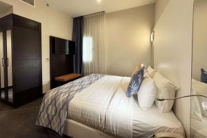 Een bed of bedden in een kamer bij Ramada Encore Doha by Wyndham