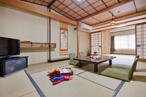 a living room with a table and a tv at Sawaki in Imabari