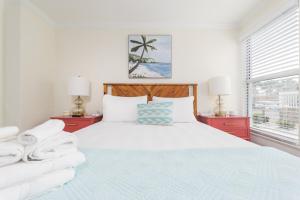 a bedroom with a bed and two red night stands at Be a Nomad - Ocean Breeze - Steps from Beach in Jacksonville Beach