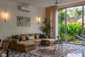a living room with a couch and a table at La Dora -3BHK Contemporary Villas with Pvt Pool, 5 mins Walk to Vagator beach-Caretaker & Garden in Vagator