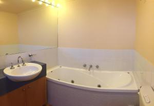 a bathroom with a bath tub and a sink at Horizons Beachfront Apartment in Port Fairy