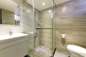 uma casa de banho com um chuveiro, um WC e um lavatório. em Blue Coast Hotel em Kaohsiung