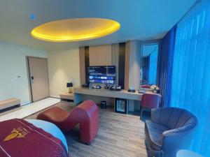 a living room with a couch and chairs and a tv at Rosy Hotel 6 in Hanoi