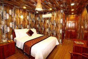 ein Schlafzimmer mit einem Bett in einem Zimmer mit Holzwänden in der Unterkunft Nest Hotel in Ho-Chi-Minh-Stadt