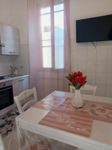 a kitchen with a table with a vase of flowers on it at La casa di Lilly in Civitavecchia