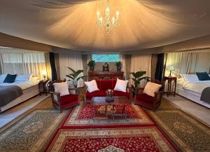 Clarence Point温顿斯豪华帐篷的一间带两张床和吊灯的客厅