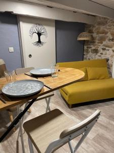 a living room with a table and a yellow couch at Séjour à la Marronnie in Saint-Germain-les-Vergnes
