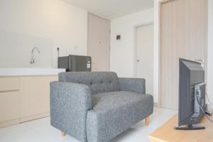 RawalembangNew Furnished and Spacious 2BR Tokyo Riverside PIK 2 Apartment By Travelio的带椅子和电视的客厅