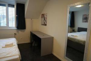 ein Zimmer mit Schreibtisch, Spiegel und zwei Betten in der Unterkunft Hotel Winkel in Schönenwerd