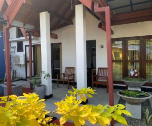 a porch of a house with yellow flowers at Mel's Inn in Negombo
