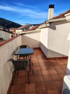 a patio with two chairs and a table on a roof at Apartamento Casa Blan in Arenas de San Pedro