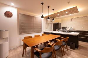 a kitchen with a wooden dining room table and chairs at Tokuno Zoo Street in Asahikawa