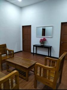 a living room with a table and chairs and a table with flowers at Noorsyah Roomstay Kangar Jaya in Kangar +7 photos