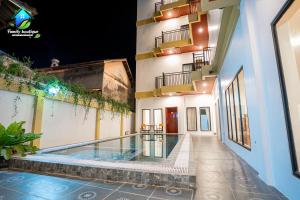 a building with a swimming pool next to a building at Family Boutique in Kampot