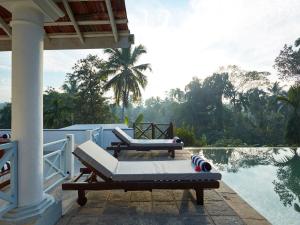 a porch with two lounge chairs and a swimming pool at Pooja Kanda in Habaraduwa Central