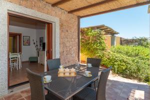 a dining room with a table and chairs on a patio at Villa Baticle in Santa Teresa Gallura