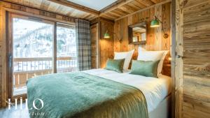 a bedroom with a large bed with a window at Hilo Suite Val d Isere Gelinotte avec Jacuzzi in Val dʼIsère +62 photos