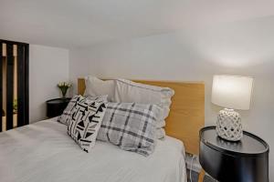 a bedroom with a bed with a lamp and pillows at Lambton Quay Loft - Sleeps 11 in Wellington